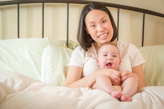 Young Mixed Race Chinese and Caucasian Baby Boy Laying In His Bed with His Mother.