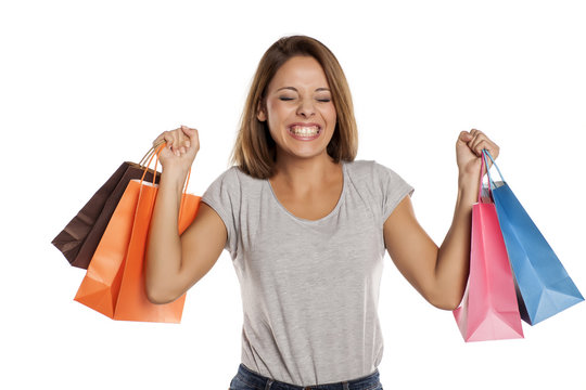 happy woman posing with shopping bags on a white background.