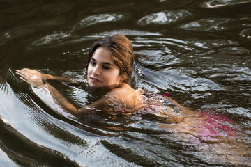 Young and pretty woman with pink bikini swimming in a river. Silvia 4099