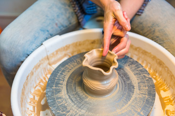 womens hands of a potter creating an earthen jar