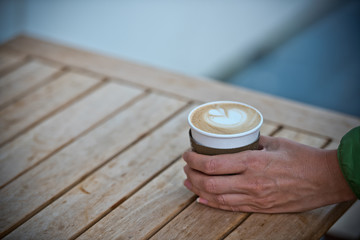 Female hand holding a paper coffee cup