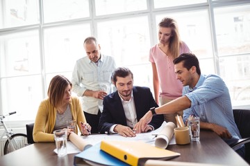 Businessman discussing with coworkers in meeting