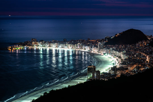 View of brightly illuminated Copacabana beach in Rio de Janeiro at night