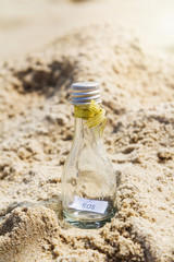 SOS message in glass bottle on the beach.