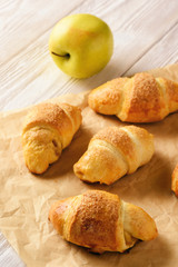 Croissants with apple jam on wooden background.