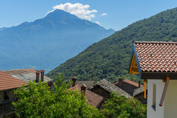 Old Italian village. Stone and tale roofs, mountains.