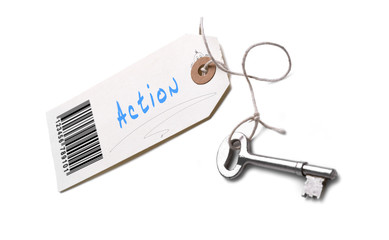 A silver key with a tag attached with a Action concept written o