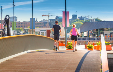 Fitness, sport, exercising and healthy lifestyle concept - woman and man running or jogging over oslo city street background.