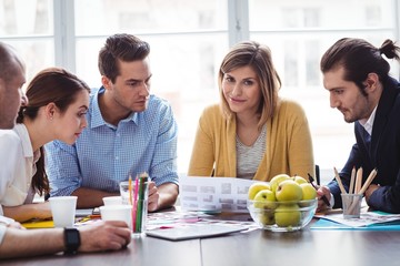 Attractive photo editor with coworkers in meeting room