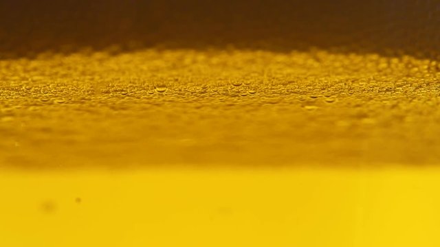 Bubbles of air carbon dioxide in beer float to the top. Slow motion