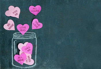 Pink paper cutout hearts are floating out of drawing of a jar out of white chalk on a rough...