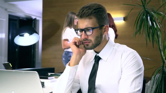 Businessman in glasses works behind a computer closeup