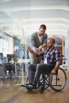 Handicap businessman discussing with colleague at office