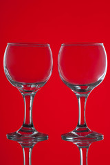 Two wine glasses on red background