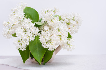 Букет белой сирени в кувшине на столе