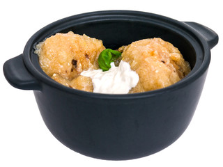 Gnocchi potatoes baked in a creamy sauce with Basil in a cast iron pot isolated on white background