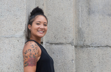 Happy hipster girl with tattoos and piercing in urban style