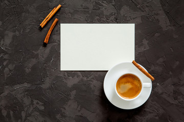 Mockup. blank paper and cup of coffee on black background. Top view