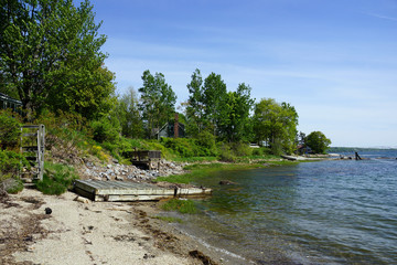 Rocky coastline with pier in distance and green trees