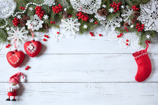 Christmas wooden background with branches of trees, lacy snowflakes, balls, red berries, sock and gnome - Powered by Adobe