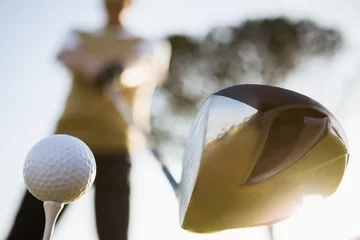Afwasbaar Fotobehang Golf Focus op de voorgrond van golfclub en bal