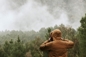 young man in the forest looking at the landscape