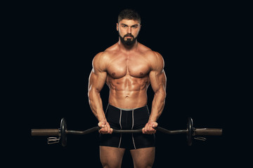 Fototapeta na wymiar Muscular male athlete is training by lifting the barbell
