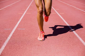 Female athlete running on the racing track