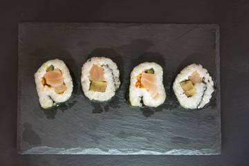 Pieces of sushi on a black stone