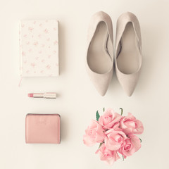 Heel shoes, notebook, lipstick, wallet and roses flat lay