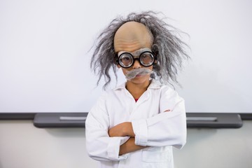 Boy dressed as scientist standing in classroom - obrazy, fototapety, plakaty