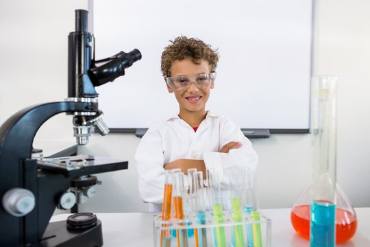 Portrait of boy standing table at laboratory