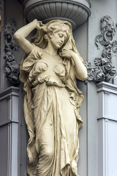 Caryatid sculpted female figure statue on the facade of a building in Tuchlauben street, Vienna, Austria