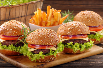 Hamburger with beef meat and fresh vegetables on wooden backgrou