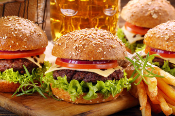 Hamburger with beef meat and fresh vegetables on wooden backgrou