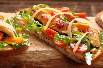 Chicken sandwich on fresh bread with arugula tomato and cheese