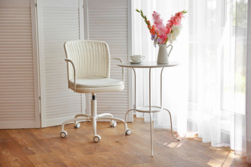 White chair in a room with flowers