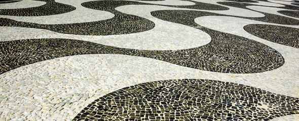 Zwart-wit iconisch mozaïek, Portugese bestrating volgens oud ontwerppatroon op het strand van Copacabana, Rio de Janeiro, Brazilië