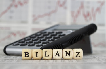 Obraz premium Bilanz mit Buchstabenwürfeln auf einer Zeitung