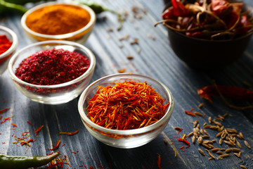 Aromatic spices in glass bowls on blue wooden background