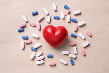Red heart with pills on table