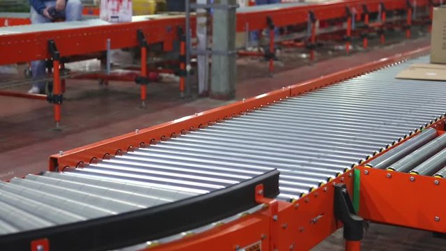Packages Shipping at Conveyer Rollers in Distribution Warehouse
