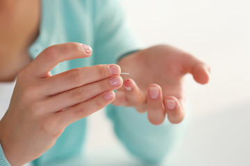 Female finger with blood drop and test stripe