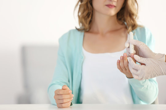Doctor using lancelet on woman finger