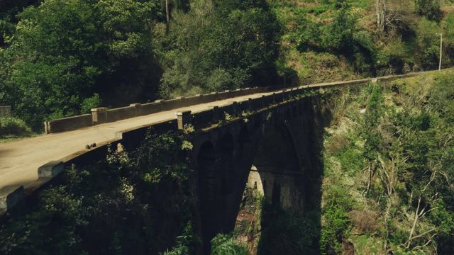 Car Goes Through an Old Bridge in a Amazing Scenary in Madeira.