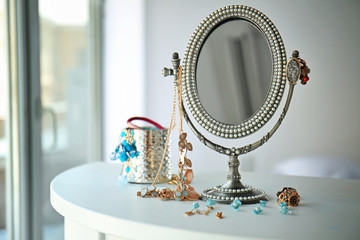 Antique silver mirror and female accessories on table