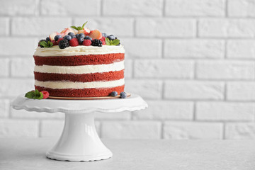 Delicious cake with fruit and berries decoration on gray table