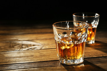 Glasses of whisky on wooden table closeup © Africa Studio