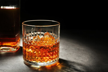 Glass of whisky on grey textured table closeup