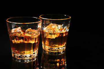 Glasses of whisky on dark background